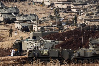 Israeli soldiers work on tanks at a staging area in northern Israel near the Israel-Lebanon border, Tuesday, Oct. 1, 2024.