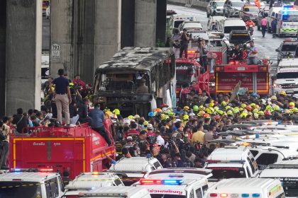 Rescuers gather around the school bus that caught fire in suburban Bangkok on October 1.