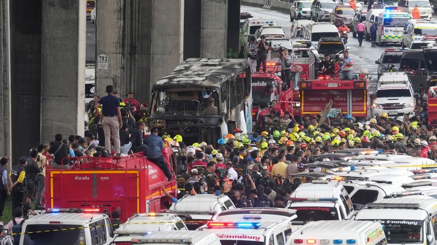 Rescuers gather around the school bus that caught fire in suburban Bangkok on October 1.