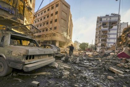 Residents run for cover following an Israeli airstrike in the Dahiyeh neighborhood of greater Beirut on Friday.