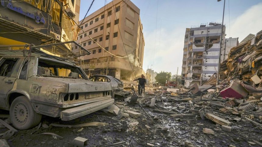 Residents run for cover following an Israeli airstrike in the Dahiyeh neighborhood of greater Beirut on Friday.