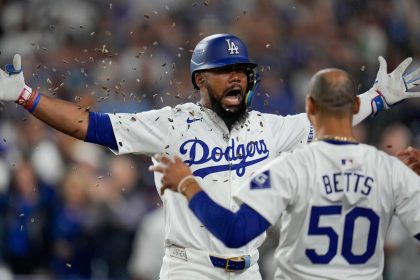 Los Angeles Dodgers' Teoscar Hernández, left, gets sunflower seeds to the face to celebrate his solo home run as Mookie Betts looks on during the seventh inning.