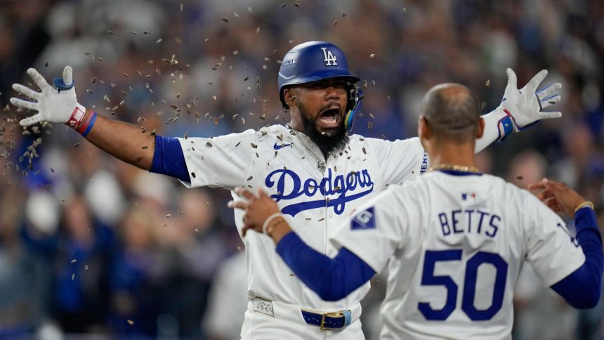 Los Angeles Dodgers' Teoscar Hernández, left, gets sunflower seeds to the face to celebrate his solo home run as Mookie Betts looks on during the seventh inning.