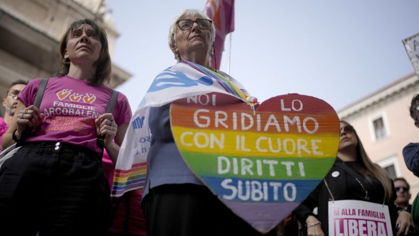 A woman shows a banner reading "we shout it from the heart, now rights" during a pro-surrogacy press conference in Rome, Tuesday, October 15, 2024.