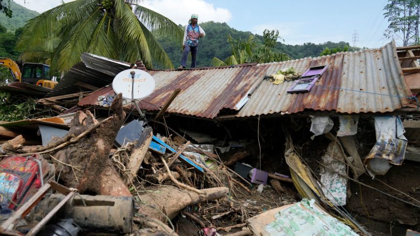 Marcelino Aringo stands on top of a damaged house after a landslide triggered by Tropical Storm Trami recently struck Talisay, Batangas province, Philippines, on Oct. 26, 2024.