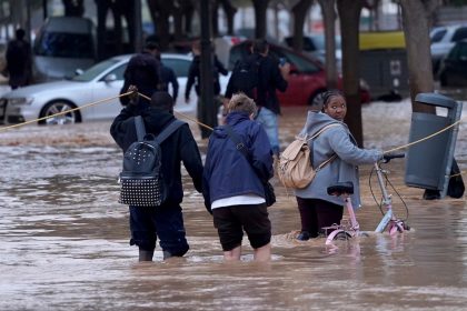 People walk through flooded streets in Valencia, Wednesday, October 30, 2024.