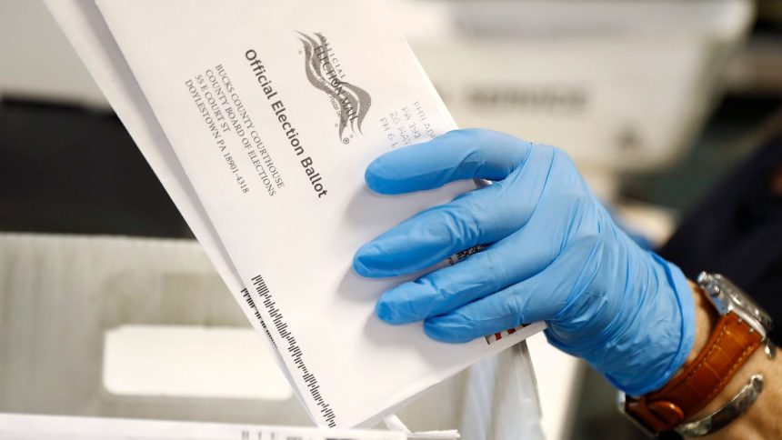 In this May 2020 photo, a worker processes mail-in ballots at the Bucks County Board of Elections office prior to the primary election in Doylestown, Pennsylvania.