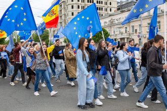 Young people wave EU and Moldovan flags in Chisinau, Moldova, to celebrate Europe Day, May 9, 2024.