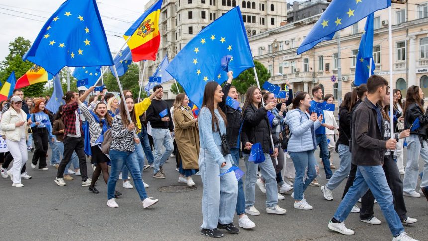 Young people wave EU and Moldovan flags in Chisinau, Moldova, to celebrate Europe Day, May 9, 2024.