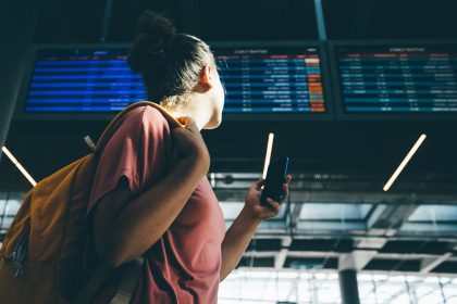 A woman checks the departures schedule at an airport.