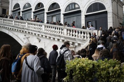 People queue to visit the Rialto Bridge on April 24, 2024 in Venice, on the eve of the start of the official trial of the city's booking system for day-trippers. Venice will begin on April 25, 2024 charging day trippers for entry, a world first aimed at easing pressure on the Italian city drowning under the weight of mass tourism. (Photo by MARCO BERTORELLO / AFP) (Photo by MARCO BERTORELLO/AFP via Getty Images)