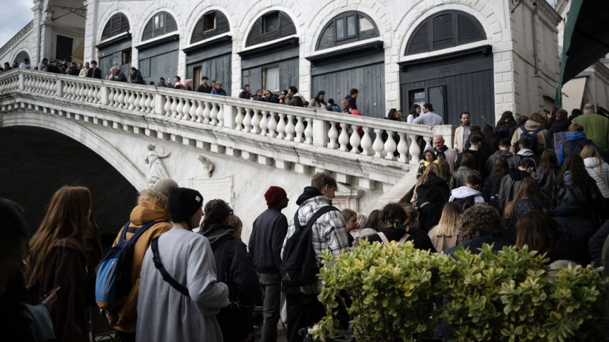 People queue to visit the Rialto Bridge on April 24, 2024 in Venice, on the eve of the start of the official trial of the city's booking system for day-trippers. Venice will begin on April 25, 2024 charging day trippers for entry, a world first aimed at easing pressure on the Italian city drowning under the weight of mass tourism. (Photo by MARCO BERTORELLO / AFP) (Photo by MARCO BERTORELLO/AFP via Getty Images)