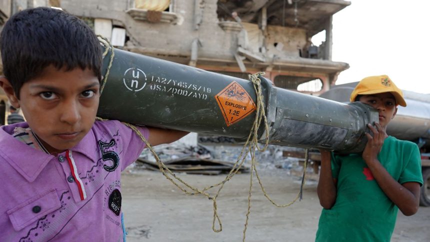 Palestinian children carry an empty US ammunition container in Khan Younis in the southern Gaza Strip on May 16, 2024.