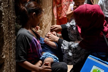 A health worker administers polio vaccine drops to a child during a vaccination campaign in Karachi on June 3, 2024.