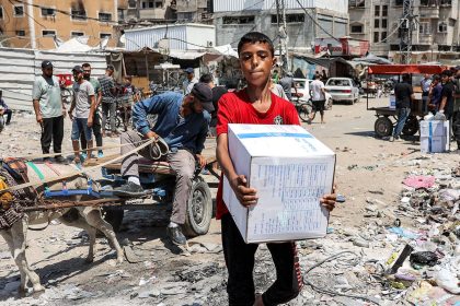 A boy carries a humanitarian aid package provided by the United Nations Relief and Works Agency for Palestine Refugees (UNRWA) in central Gaza City on August 27.