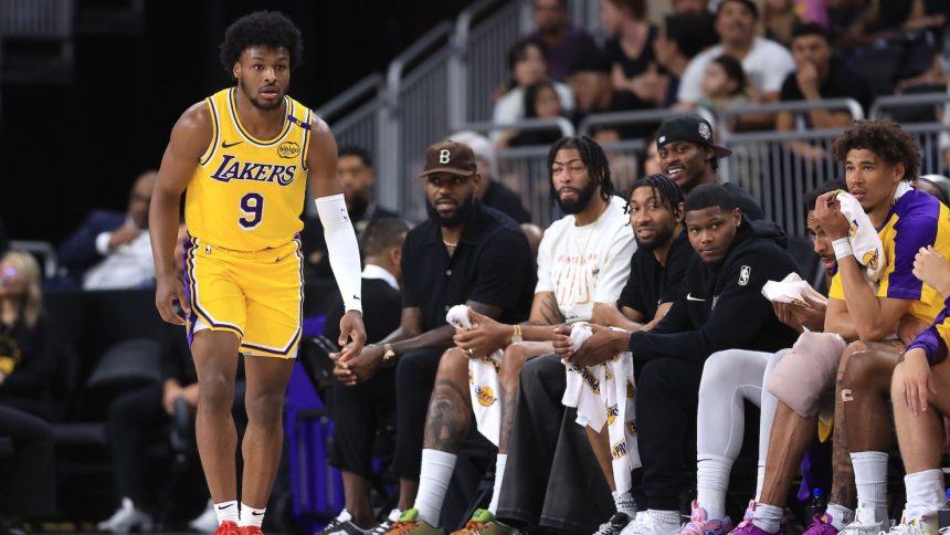 LeBron James watches the game from the bench as Bronny James makes his preseason debut.