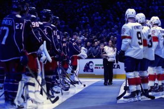 Meredith Gaudreau, the widow of Johnny Gaudreau, walks out onto the ice at a ceremony honoring the late Columbus Blue Jackets player