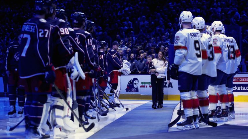 Meredith Gaudreau, the widow of Johnny Gaudreau, walks out onto the ice at a ceremony honoring the late Columbus Blue Jackets player