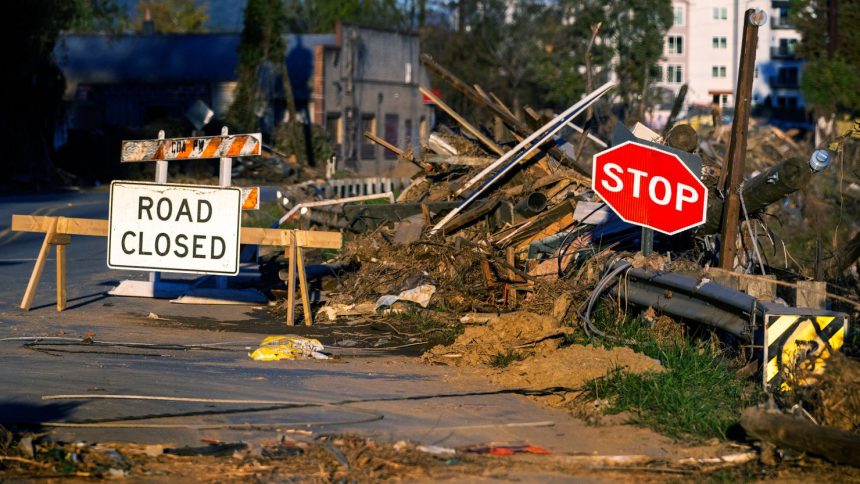 Debris covers a closed street near the Swannanoa River in Asheville, North Carolina, on October 20, 2024, as clean-up efforts continue after Hurricane Helene devastated the area.