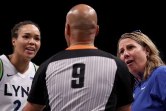 Minnesota Lynx forward Napheesa Collier and head coach Cheryl Reeve discuss a foul call with a game official in the fourth quarter of Game Five of the WNBA Finals.