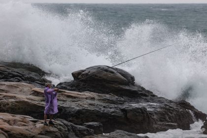 A man goes fishing near high waves as Super Typhoon Kong-rey approaches in Keelung in the northeastern part of Taiwan on October 29, 2024.