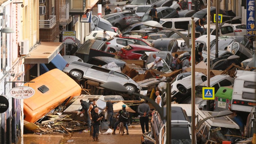 Cars are piled in the street with other debris in Valencia, Spain after flash floods hit the region.