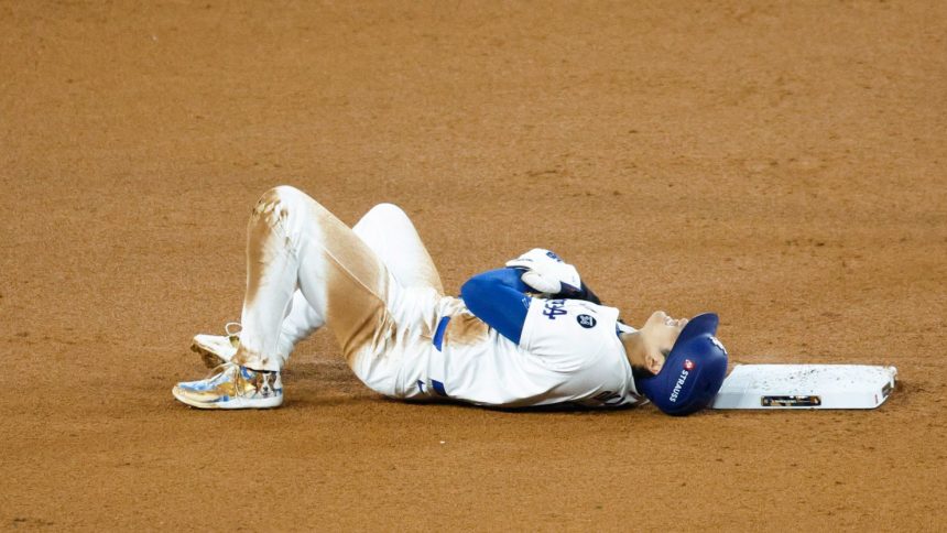 Shohei Ohtani of the Los Angeles Dodgers lies on the ground injured after attempting to steal second base in the seventh inning during Game 2 of the 2024 World Series at Dodger Stadium on Saturday in Los Angeles, California.