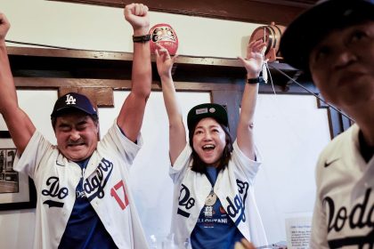 Los Angeles Dodgers fans, tourists from Japan, cheer while watching Game 3 of the World Series against the New York Yankees in the Far Bar in Little Tokyo in Los Angeles, California, on October 28, 2024.