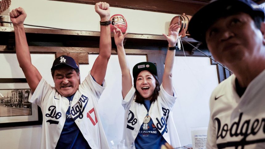 Los Angeles Dodgers fans, tourists from Japan, cheer while watching Game 3 of the World Series against the New York Yankees in the Far Bar in Little Tokyo in Los Angeles, California, on October 28, 2024.