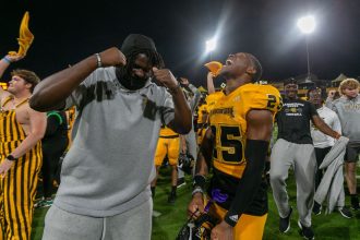 Kennesaw State Owls players and fans celebrate the program's first ever FBS victory after the game against the Liberty Flames at Fifth Third Stadium.