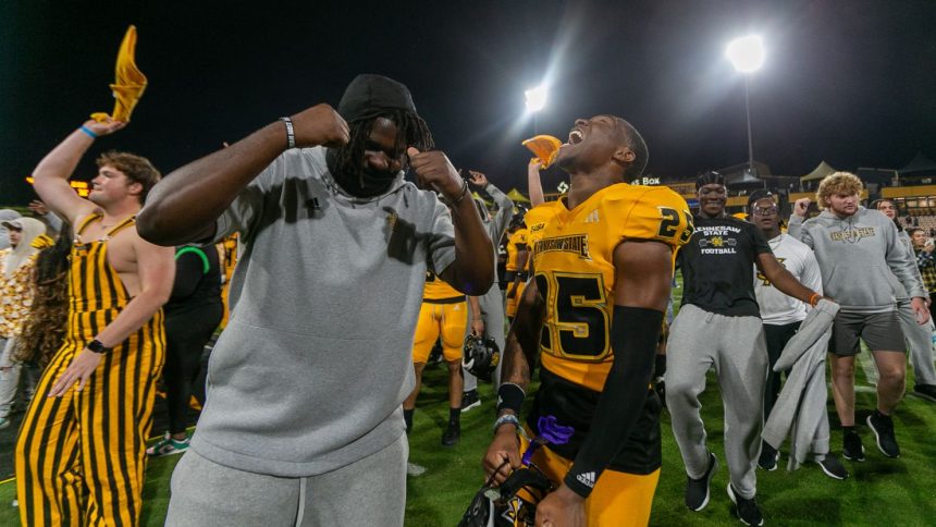 Kennesaw State Owls players and fans celebrate the program's first ever FBS victory after the game against the Liberty Flames at Fifth Third Stadium.