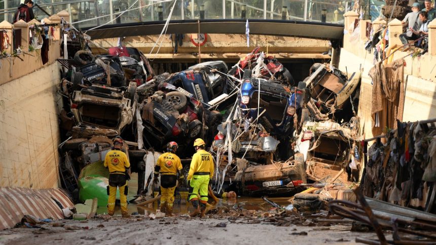 Members of a fire brigade search and rescue unit work on November 1, 2024 as cars and debris block a tunnel after flash flooding in the Benetusser municipality of Valencia, Spain.