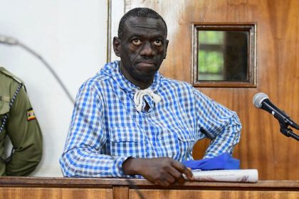 Veteran Ugandan opposition leader Kizza Besigye stands in the dock at the courtroom where he was charged with inciting violence during a protest against soaring consumer prices, in Kampala, Uganda May 25, 2022.