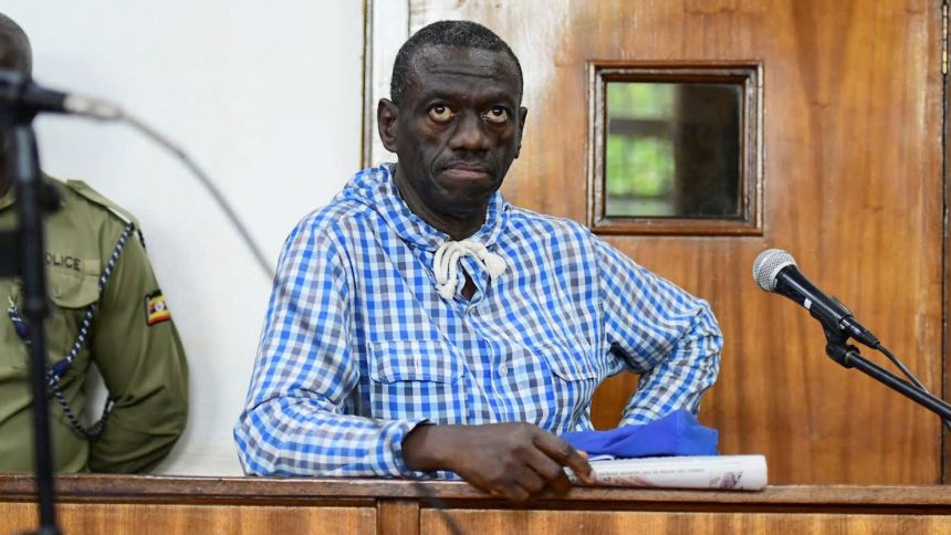 Veteran Ugandan opposition leader Kizza Besigye stands in the dock at the courtroom where he was charged with inciting violence during a protest against soaring consumer prices, in Kampala, Uganda May 25, 2022.