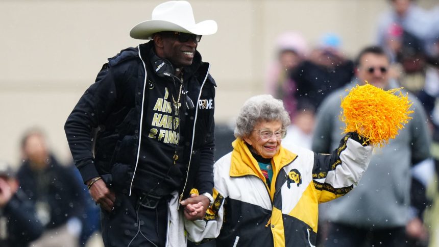 Apr 22, 2023; Boulder, CO, USA; Colorado Buffaloes head coach holds the hand of fan Peggy Coppom before the start of the spring game at Folsom Filed. Mandatory Credit: Ron Chenoy-USA TODAY Sports