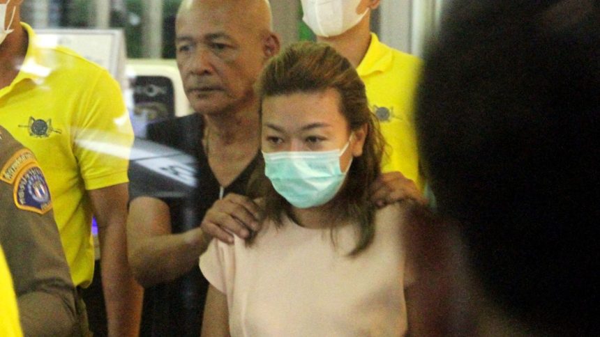 Sararat Rangsiwuthaporn is escorted by officers at a police station in Bangkok, Thailand on April 26, 2023.