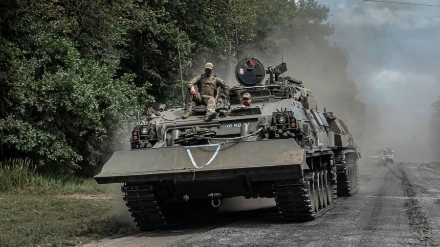 FILE PHOTO: Ukrainian servicemen ride a military vehicle in the Sumy region, near the Russian border on August 10, 2024.