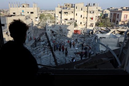 A Palestinian man looks out of a damaged window as he views the site of an Israeli strike on a house, amid the Israel-Hamas conflict, in Nuseirat in the central Gaza Strip on November 7.