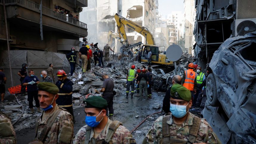 Civil defense members work as Lebanese army soldiers stand guard at the site of an Israeli strike in the Basta neighborhood of Beirut, Lebanon, on November 23, 2024.