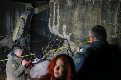 People stand near the damaged canal in northern Kosovo on Friday. The canal supplies water to two coal-fired power plants that generate nearly all of the country's electricity.