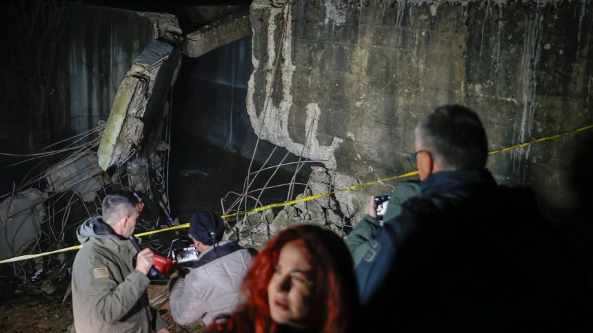 People stand near the damaged canal in northern Kosovo on Friday. The canal supplies water to two coal-fired power plants that generate nearly all of the country's electricity.