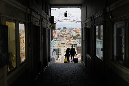 A couple pull suitcases along an alley in Lisbon in February 2022. Portugal's Golden Residence Permit Program is popular among Americans.