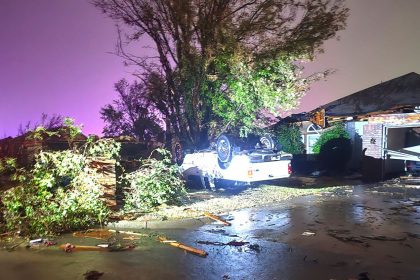 A vehicle is seen flipped over near a damaged home after a tornado hit the area in Midwest City, Oklahoma.