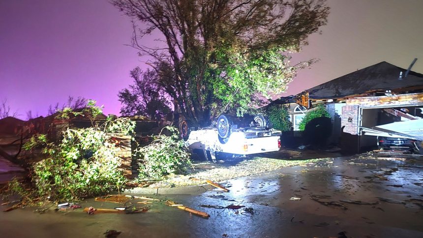 A vehicle is seen flipped over near a damaged home after a tornado hit the area in Midwest City, Oklahoma.