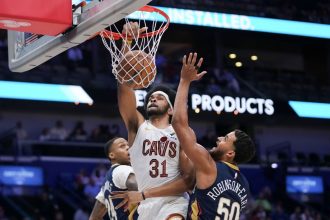 Cleveland Cavaliers center Jarrett Allen dunks between New Orleans Pelicans forward Jeremiah Robinson-Earl and guard Jordan Hawkins in the first half at Smoothie King Center.