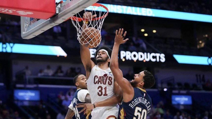 Cleveland Cavaliers center Jarrett Allen dunks between New Orleans Pelicans forward Jeremiah Robinson-Earl and guard Jordan Hawkins in the first half at Smoothie King Center.