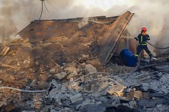 Emergency services personnel work to extinguish a fire following a Russian rocket attack in Lviv, Ukraine, on November 17.