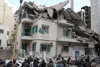 Residents and rescuers gather at the site of an Israeli airstrike that hit a building in central Beirut's Ras el-Nabaa neighborhood, Lebanon on Sunday.