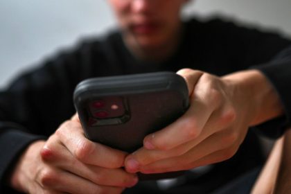 A teenager uses his mobile phone to access social media, in Sydney, Australia, on November 13, 2024.