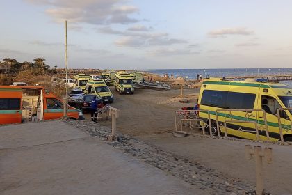 Rescuers and ambulance cars wait on the beach for possible survivors after a boat sank at a harbor in Marsa Alam, Egypt.